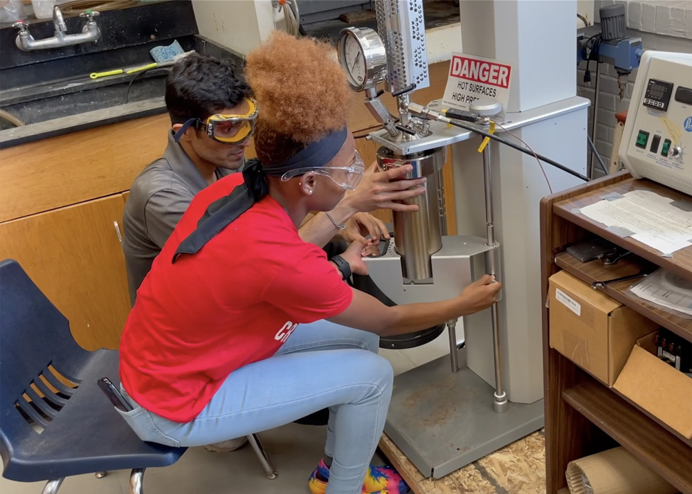 Vir Sagar working with student I’keia Brown on a lab project.