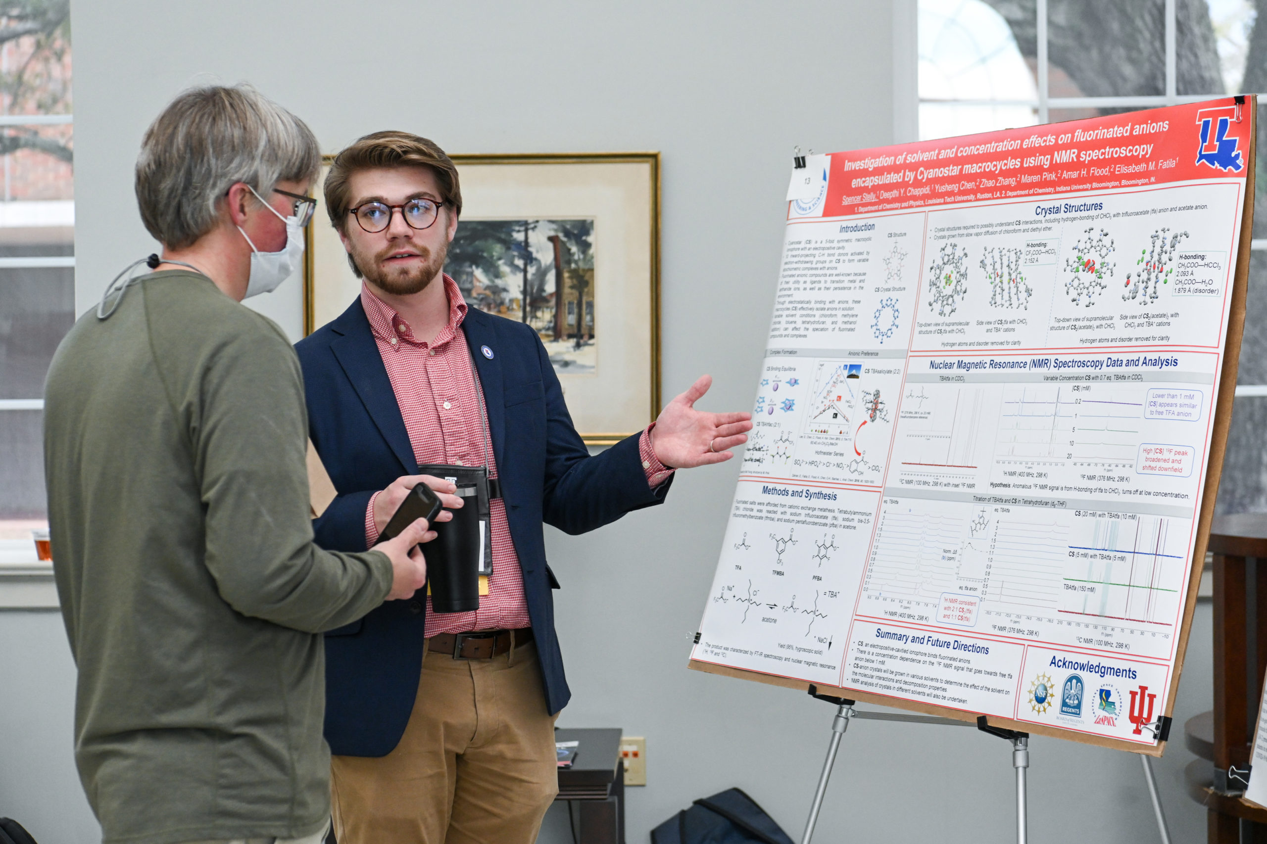 Attendees discussing a poster at the Undergraduate Research Symposium