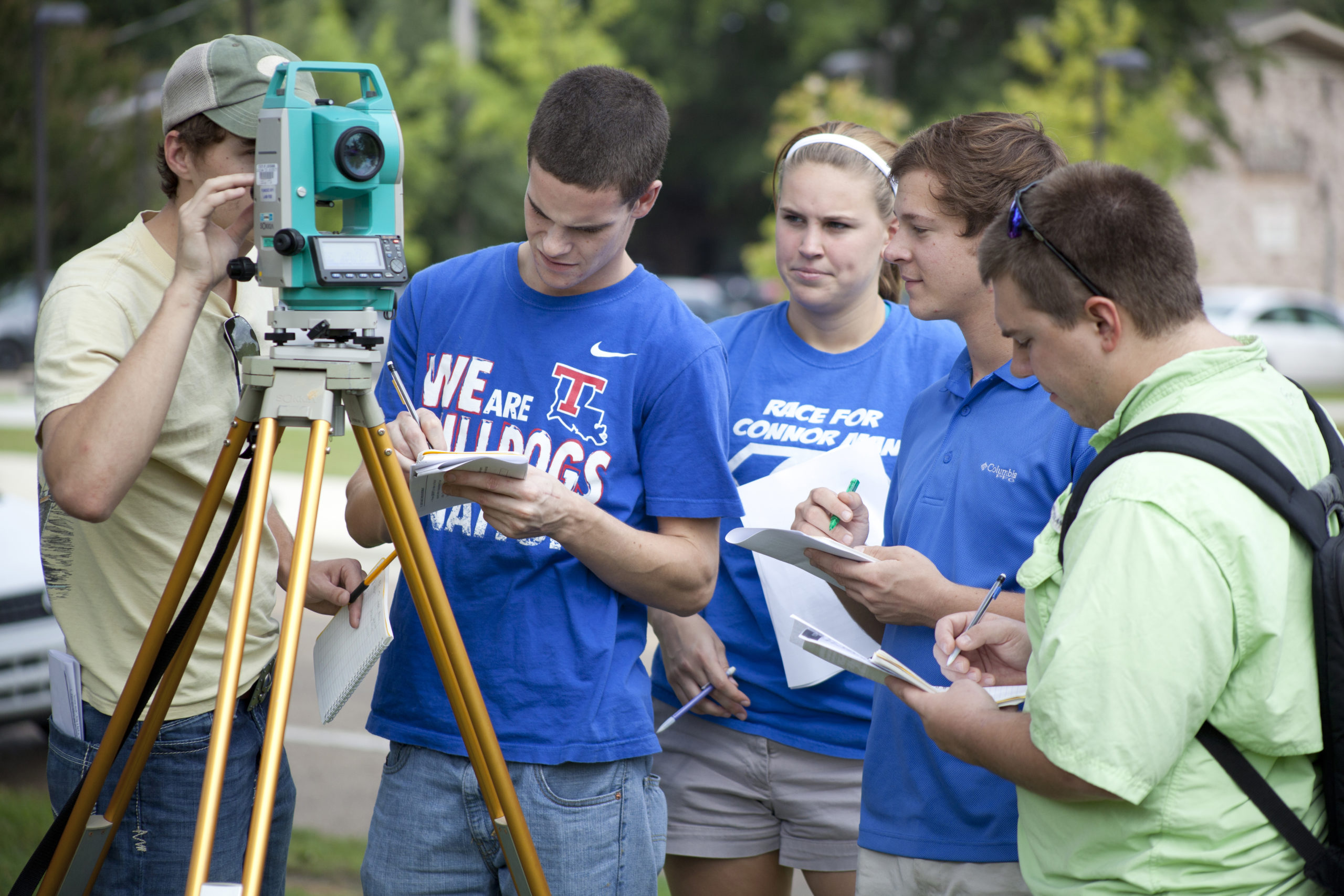 Students making notes as they use surveying equipment