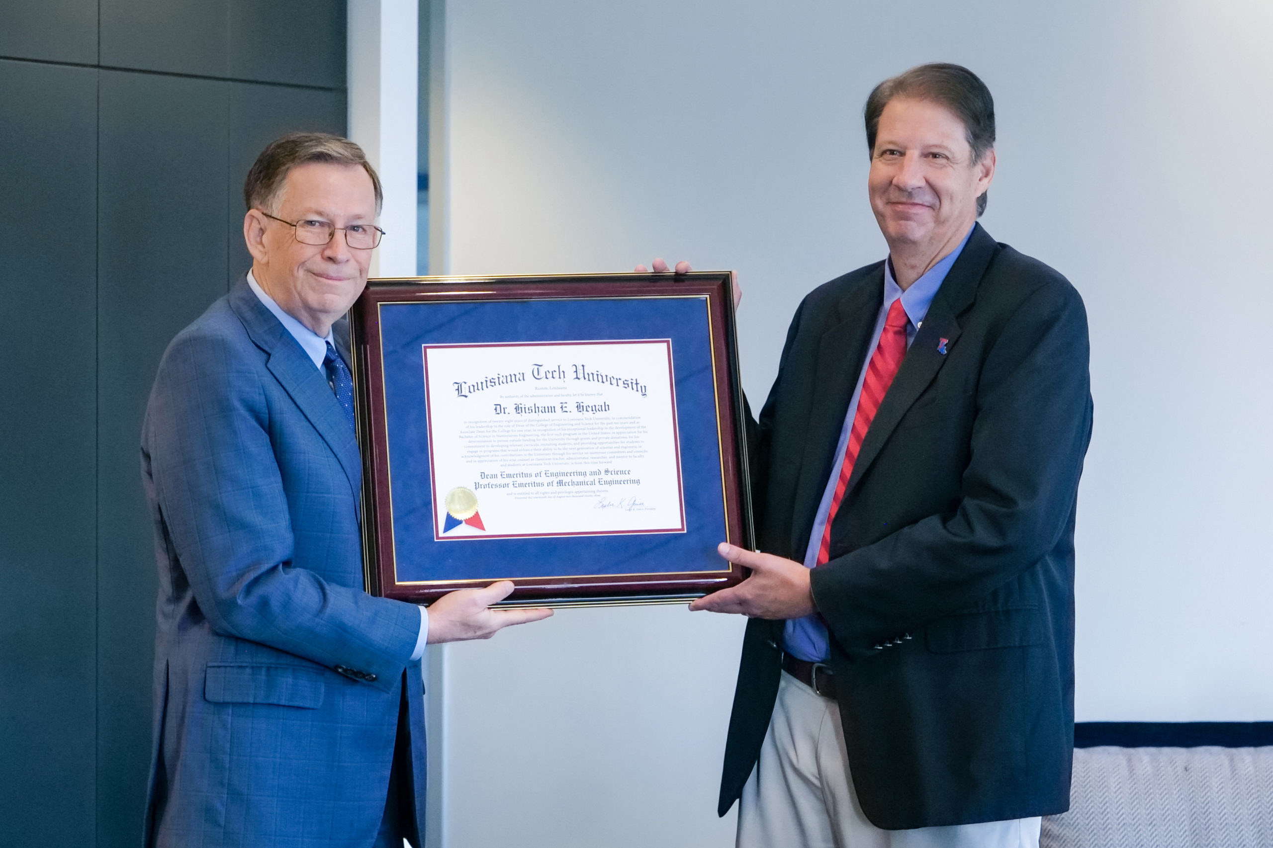 Louisiana Tech President Dr. Les Guice presenting COES Dean Emeritus Dr. Hisham Hegab with a plaque honoring his service to the University